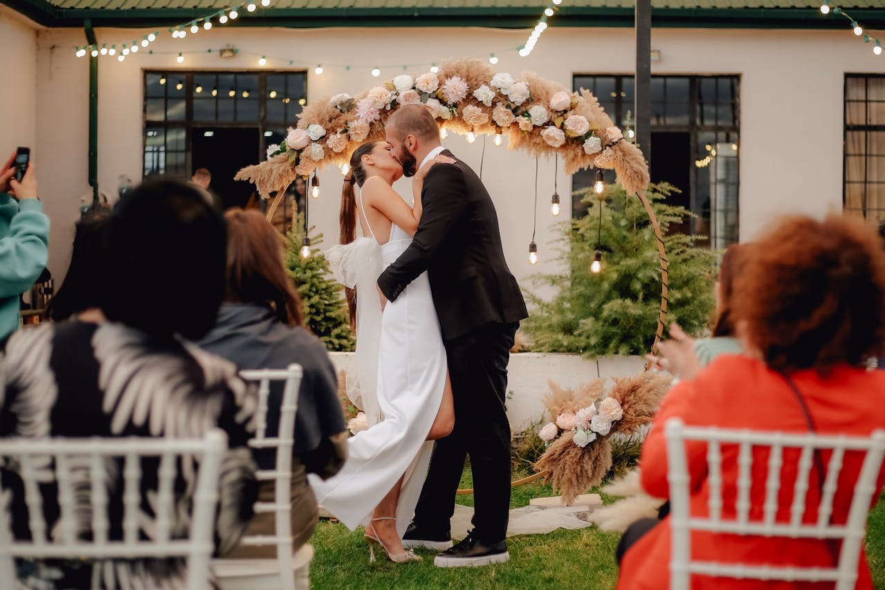 Bride and groom kissing during an outdoor wedding ceremony